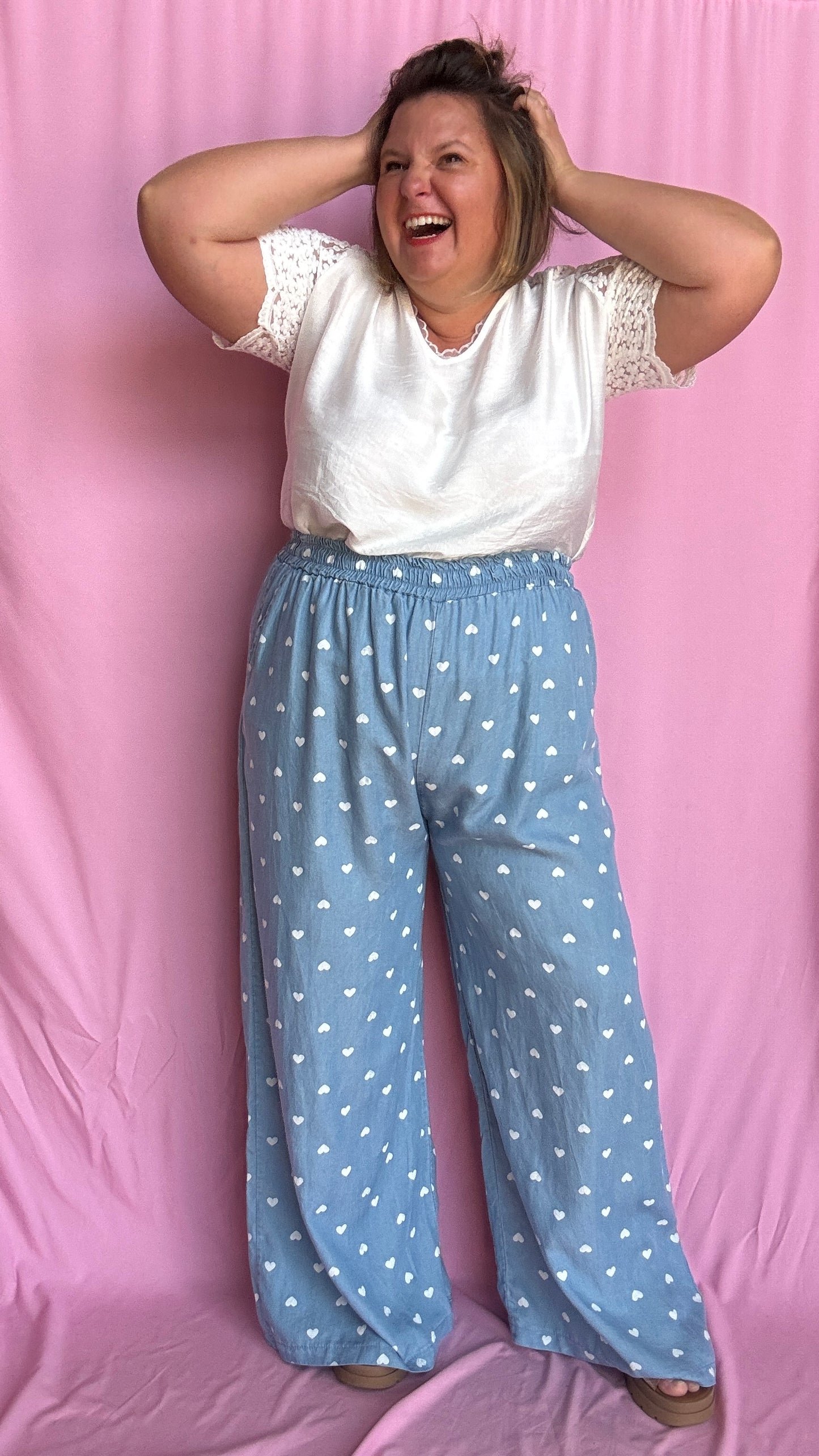 Avec sa coupe droite et jambes larges, ce pantalon fluide bleu ciel motifs coeur blanc est parfait pour bouger librement tout en étant stylée.