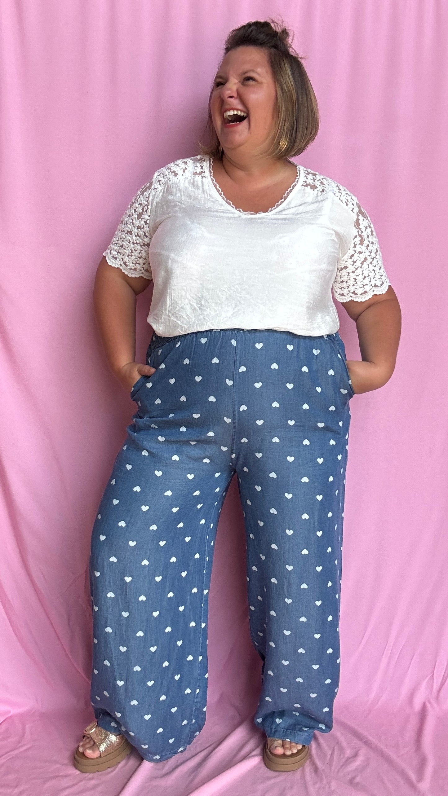Avec sa coupe droite et jambes larges, ce pantalon fluide bleu jean motifs coeur blanc est parfait pour bouger librement tout en étant stylée.