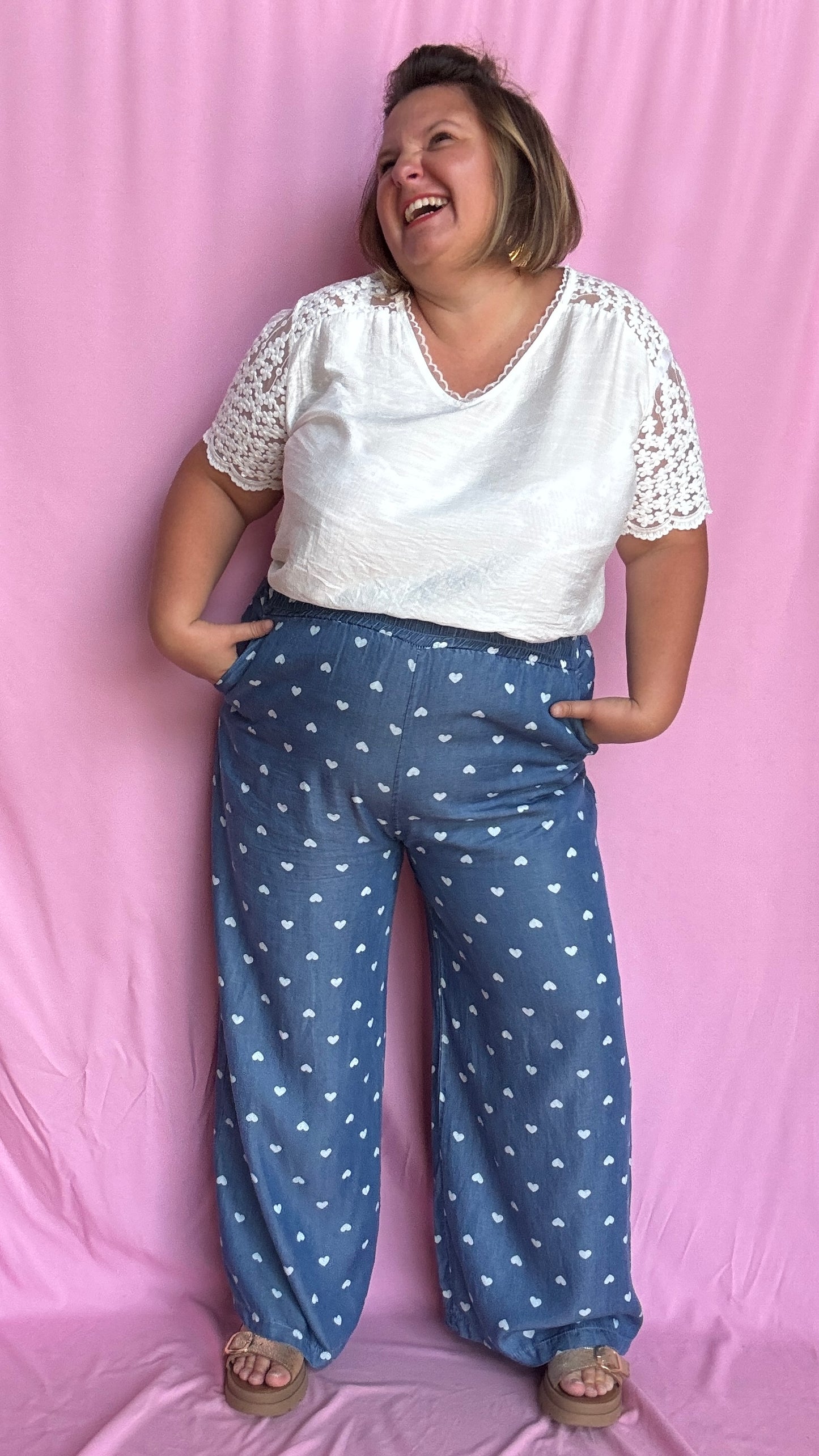 Avec sa coupe droite et jambes larges, ce pantalon fluide bleu jean motifs coeur blanc est parfait pour bouger librement tout en étant stylée.
