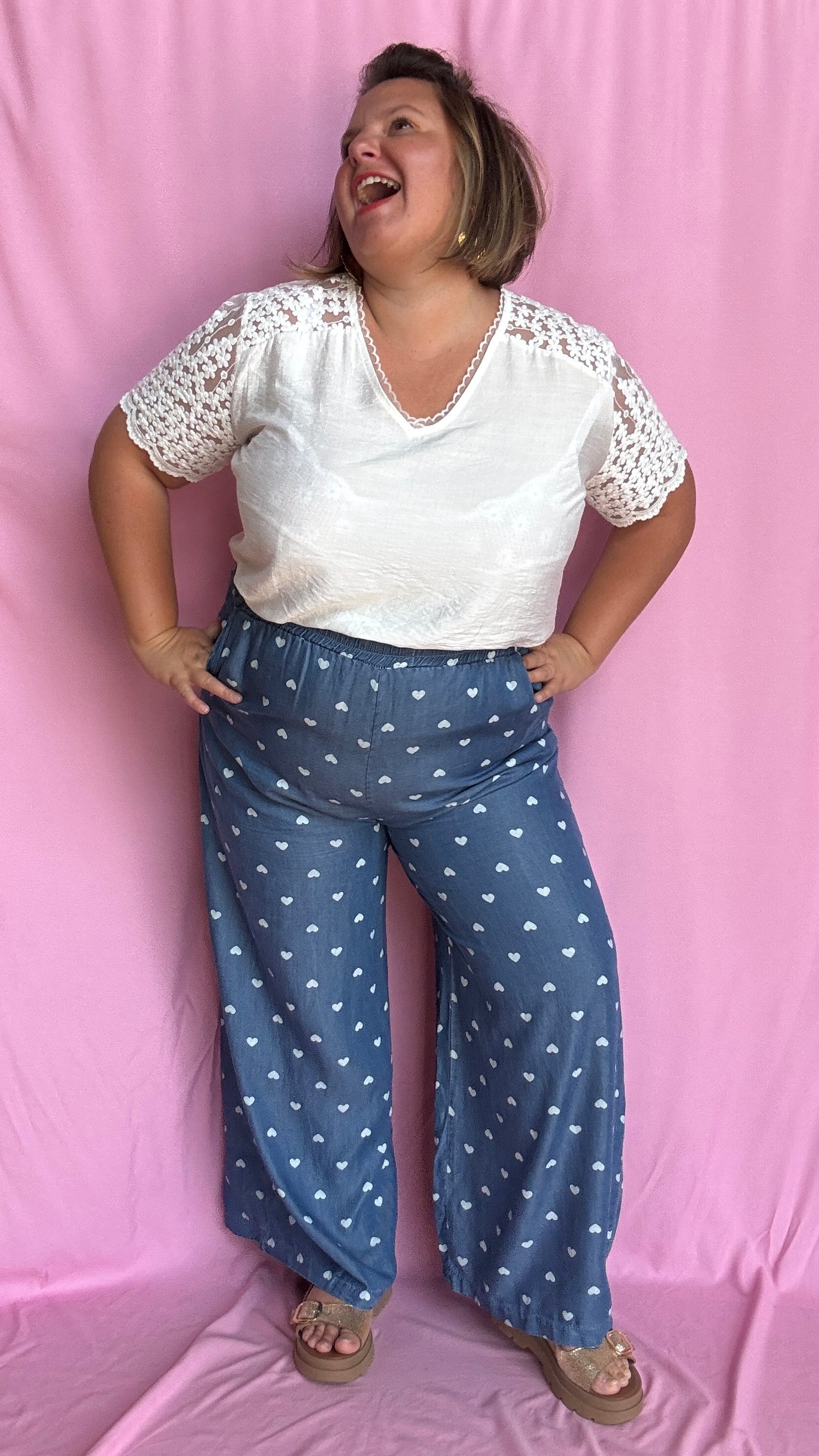 Avec sa coupe droite et jambes larges, ce pantalon fluide bleu jean motifs coeur blanc est parfait pour bouger librement tout en étant stylée.