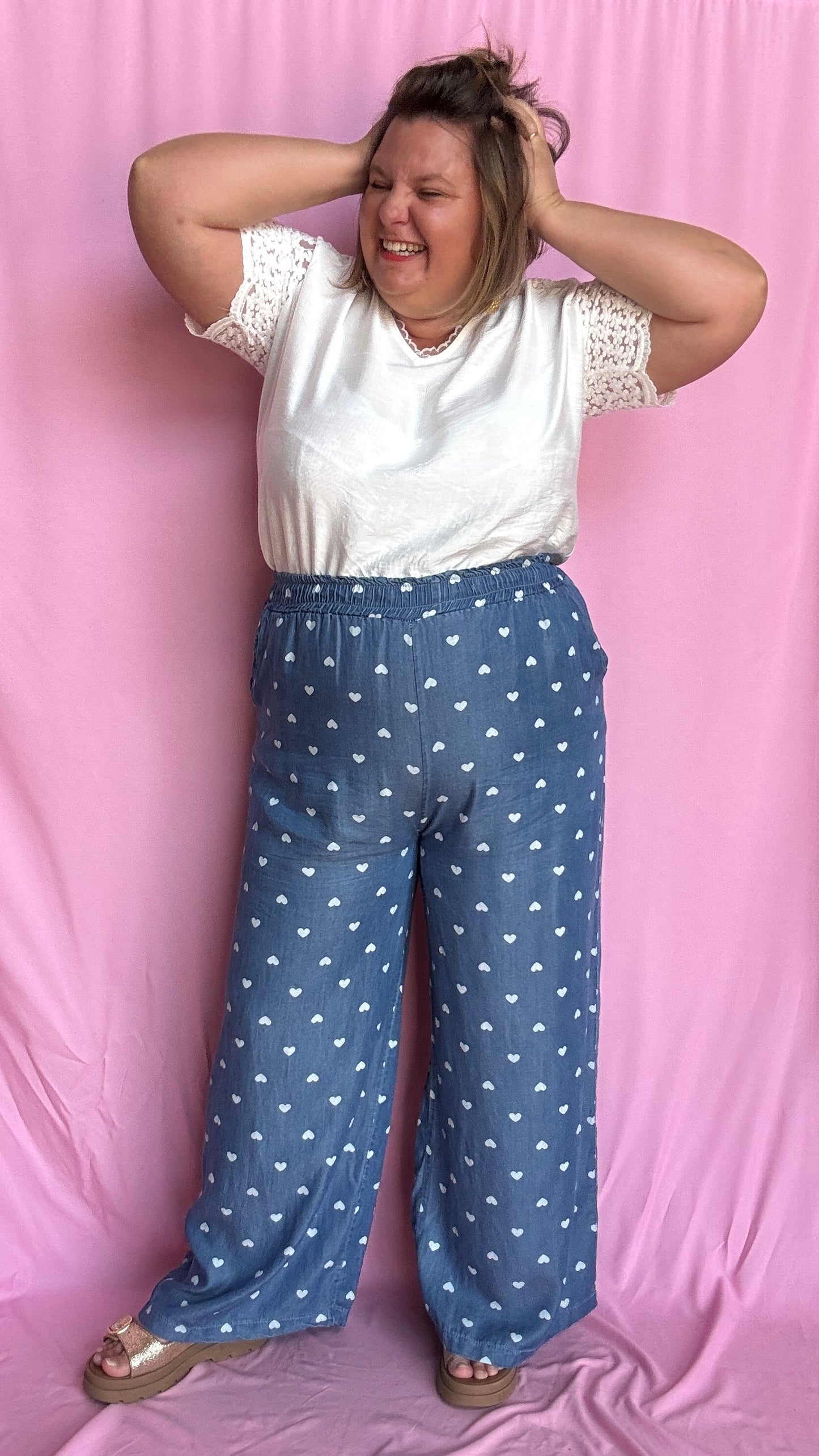 Avec sa coupe droite et jambes larges, ce pantalon fluide bleu jean motifs coeur blanc est parfait pour bouger librement tout en étant stylée.