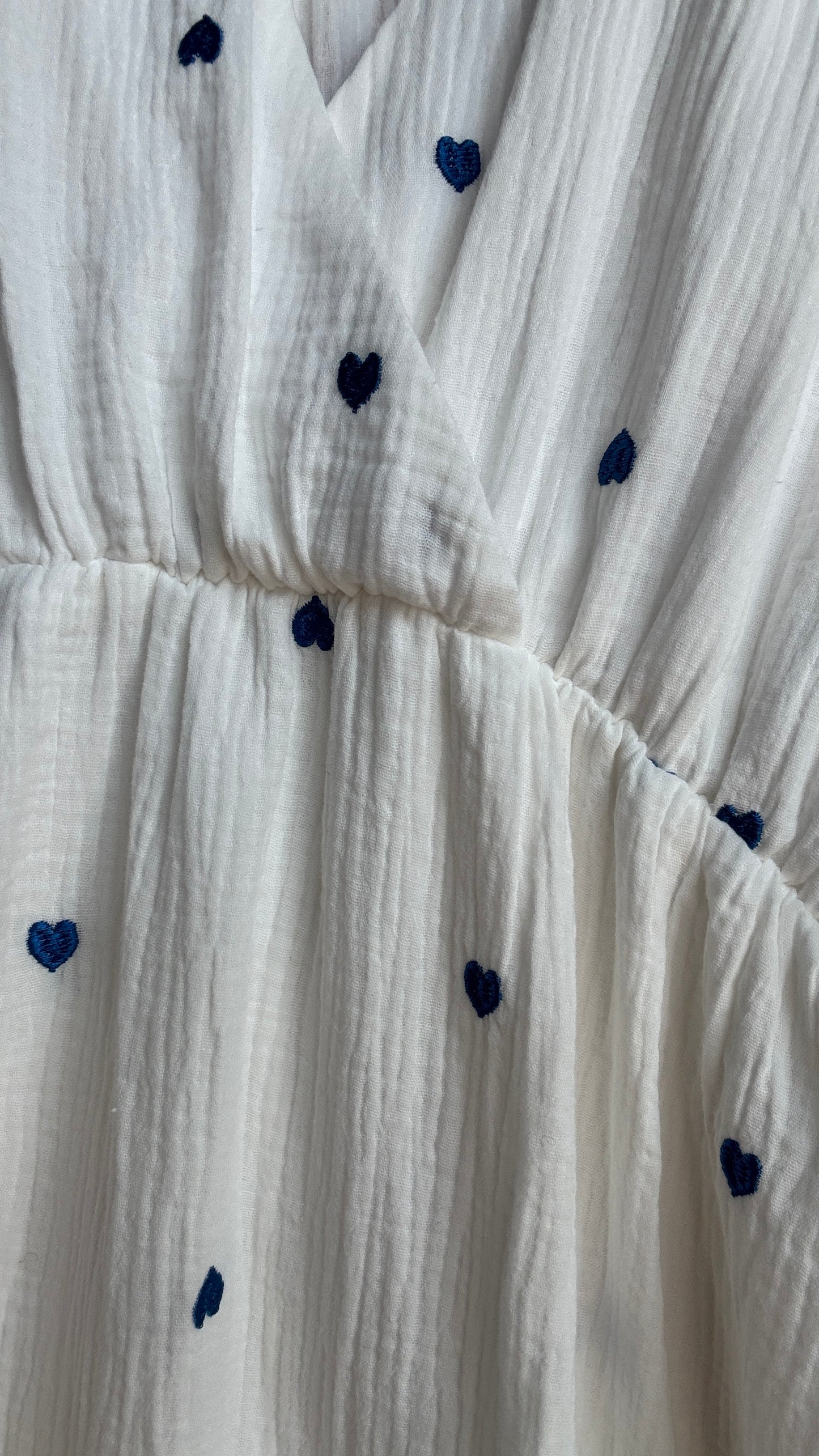 Cette robe longue grande taille en gaze de coton blanche est sublimée par de jolis motifs cœurs bleus qui ajoutent une touche de tendresse et de fantaisie