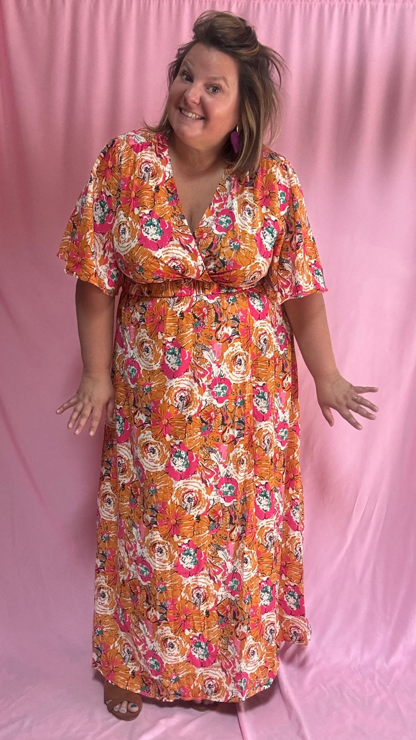 Un vent de fraîcheur et de féminité souffle sur ta garde-robe avec cette magnifique robe longue grande taille aux motifs fleuris dans des tons orange et rose 🌷