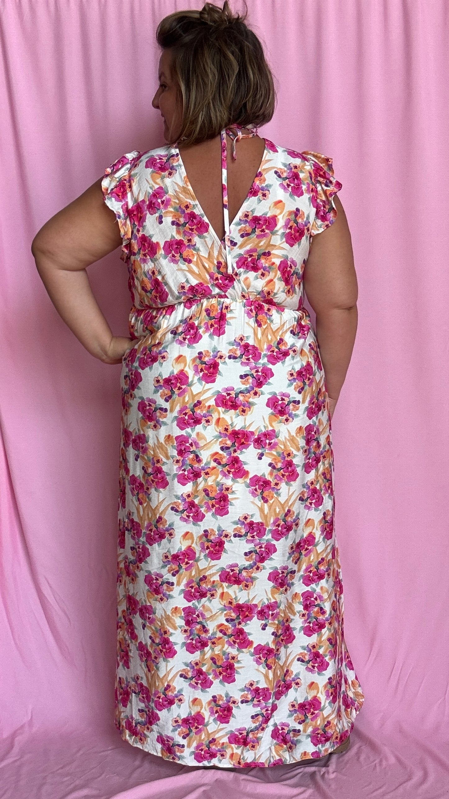 Cette robe grande taille fluide et féminine marie à merveille un fond beige doux avec de jolis motifs fleuris rose orangé,