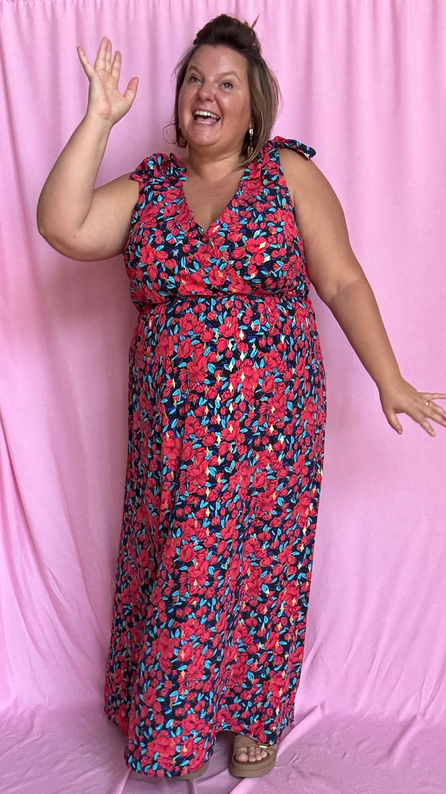 Une robe longue grande taille ultra féminine et pleine d'élégance, avec ses magnifiques motifs fleuris dans les tons rouge, bleu et doré et son dos nu.