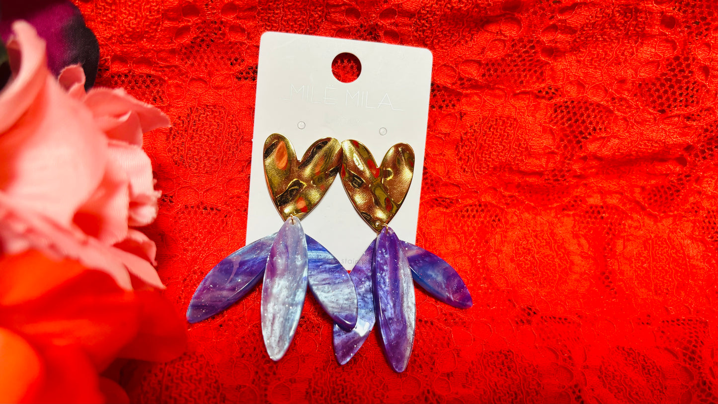 Avec ces boucles d'oreilles en acier inoxydable cœur doré et pendants violets, vous apporterez une touche de couleur et de verticalité à vos tenues, alliant confort et élégance au quotidien.