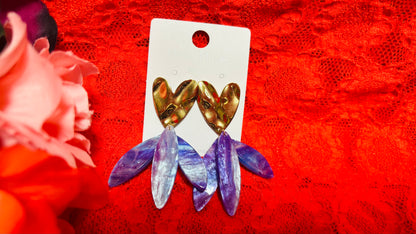 Avec ces boucles d'oreilles en acier inoxydable cœur doré et pendants violets, vous apporterez une touche de couleur et de verticalité à vos tenues, alliant confort et élégance au quotidien.