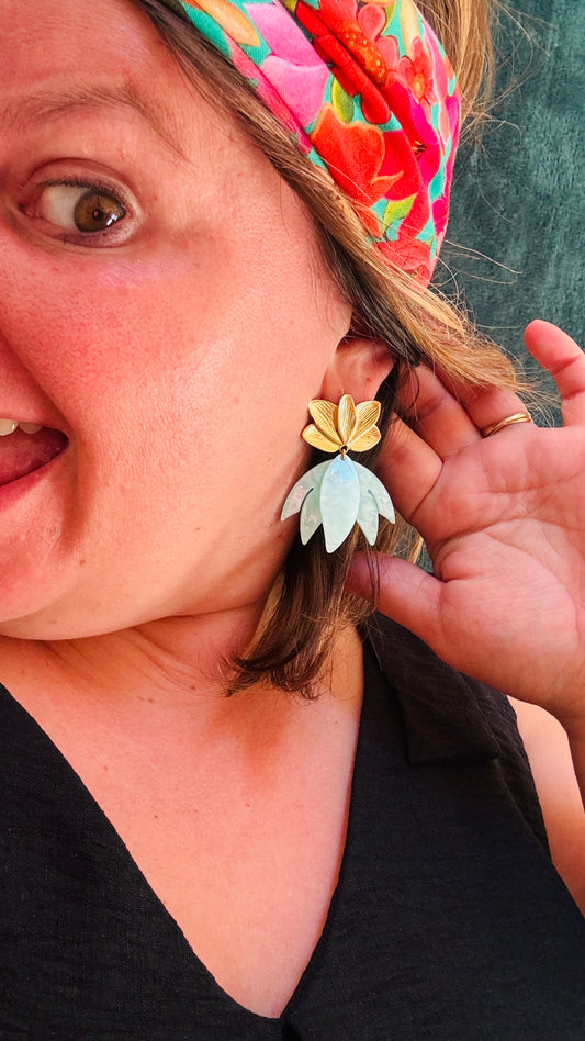 Avec ces boucles d'oreilles en acier inoxydable fleur de nénuphar et pendants vert d'eau, vous apporterez une touche de verticalité et de luminosité à vos tenues, alliant confort et élégance au quotidien.
