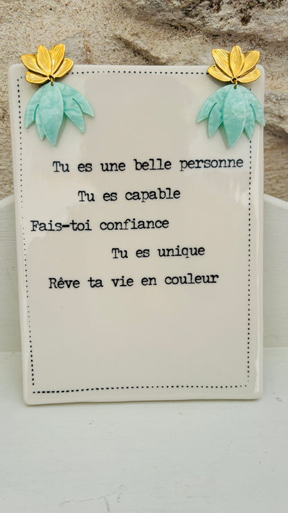 Avec ces boucles d'oreilles en acier inoxydable fleur de nénuphar et pendants vert d'eau, vous apporterez une touche de verticalité et de luminosité à vos tenues, alliant confort et élégance au quotidien.