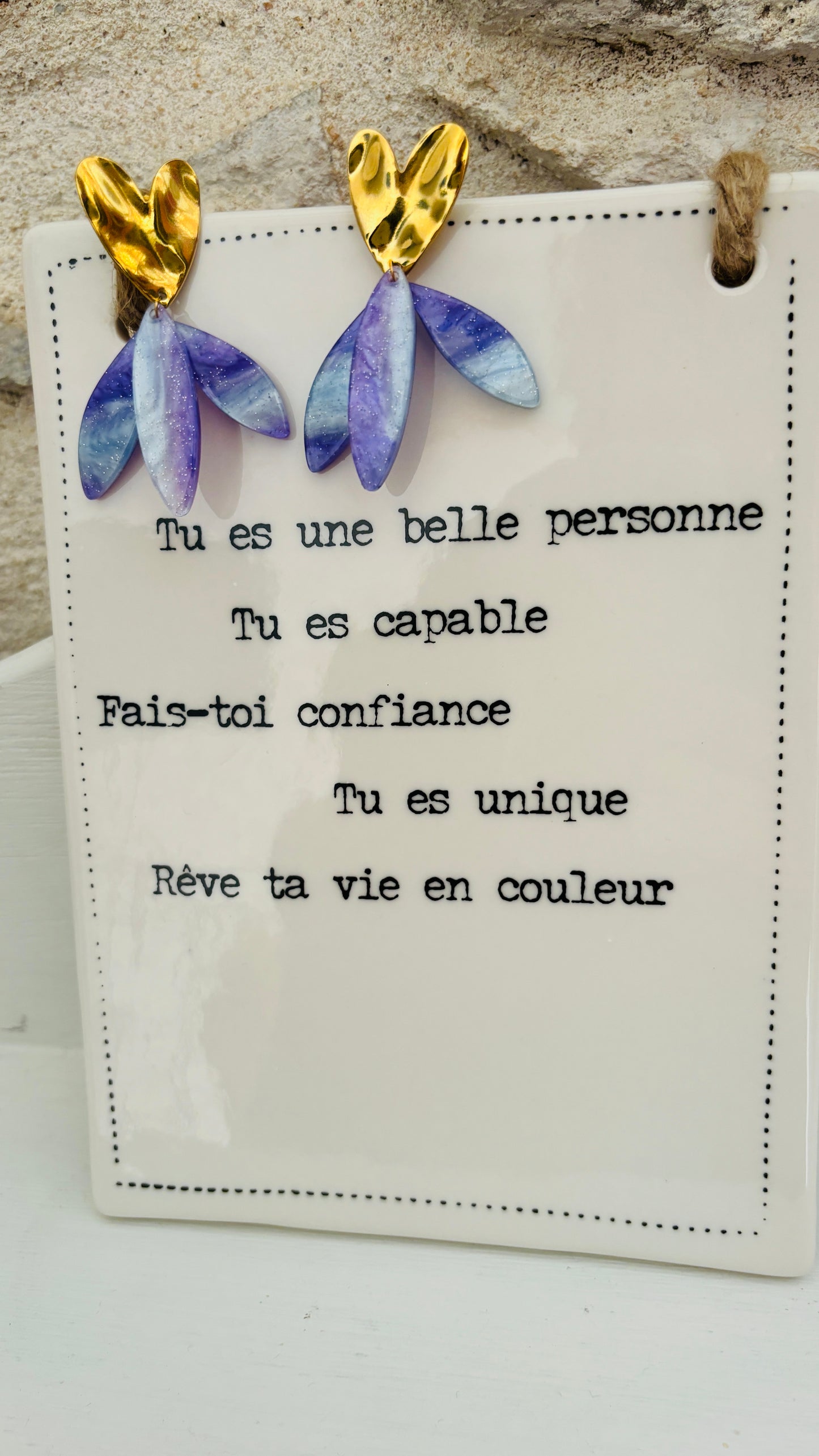 Avec ces boucles d'oreilles en acier inoxydable cœur doré et pendants violets, vous apporterez une touche de couleur et de verticalité à vos tenues, alliant confort et élégance au quotidien.