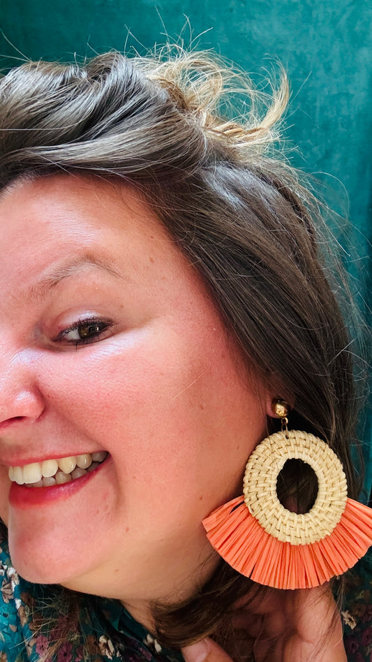 Ces boucles d'oreilles en raphia orange corail sont l'accessoire parfait pour apporter une touche de couleur et de nature à vos tenues, sans compromettre le confort ou le style.