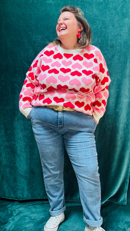 Ajoutez ce pull grande taille à motifs cœurs rouge et rose à votre collection pour allier douceur, originalité et style romantique tout en restant au chaud cet hiver.