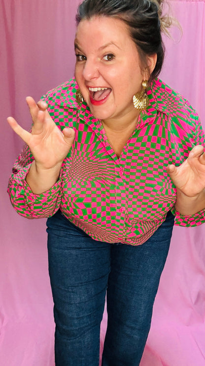 Cette blouse grande taille verte et rose est la pièce phare pour toutes celles qui souhaitent ajouter de la couleur et du caractère à leur style, tout en restant à l’aise et confortables.