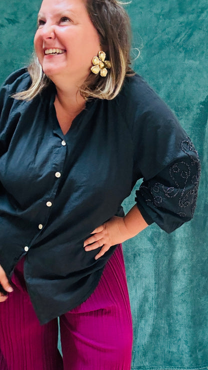 Cette blouse grande taille  noire aux détails scintillants et manches ballon est la pièce idéale pour apporter de l'originalité à votre look tout en restant élégante et confortable.