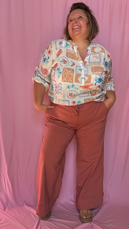 Une chemise grande taille aussi craquante qu’originale aux motifs coquillages et crustacés bleu corail beige et vert