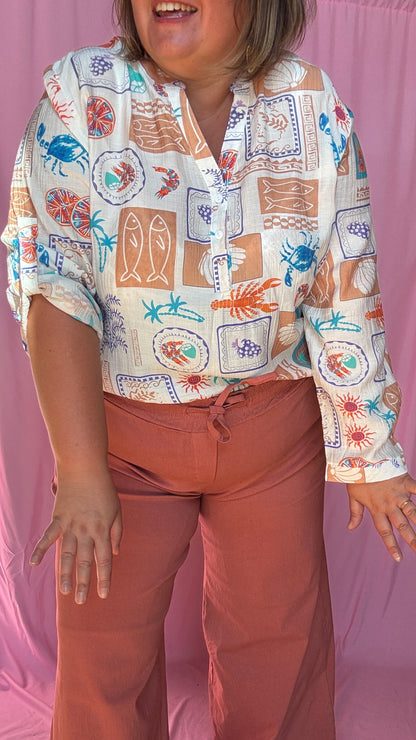 Une chemise grande taille aussi craquante qu’originale aux motifs coquillages et crustacés bleu corail beige et vert