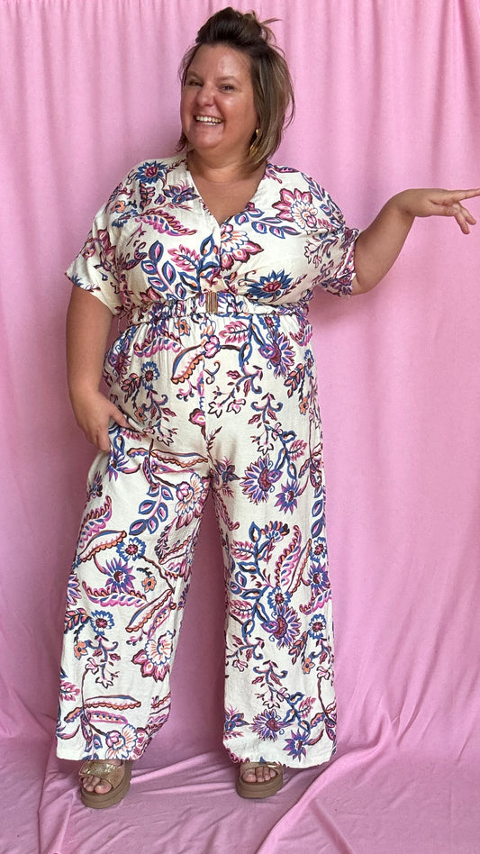 Une combinaison grande taille ultra élégante et fluide, sublimée par de délicats motifs bleus et violets sur fond blanc.
