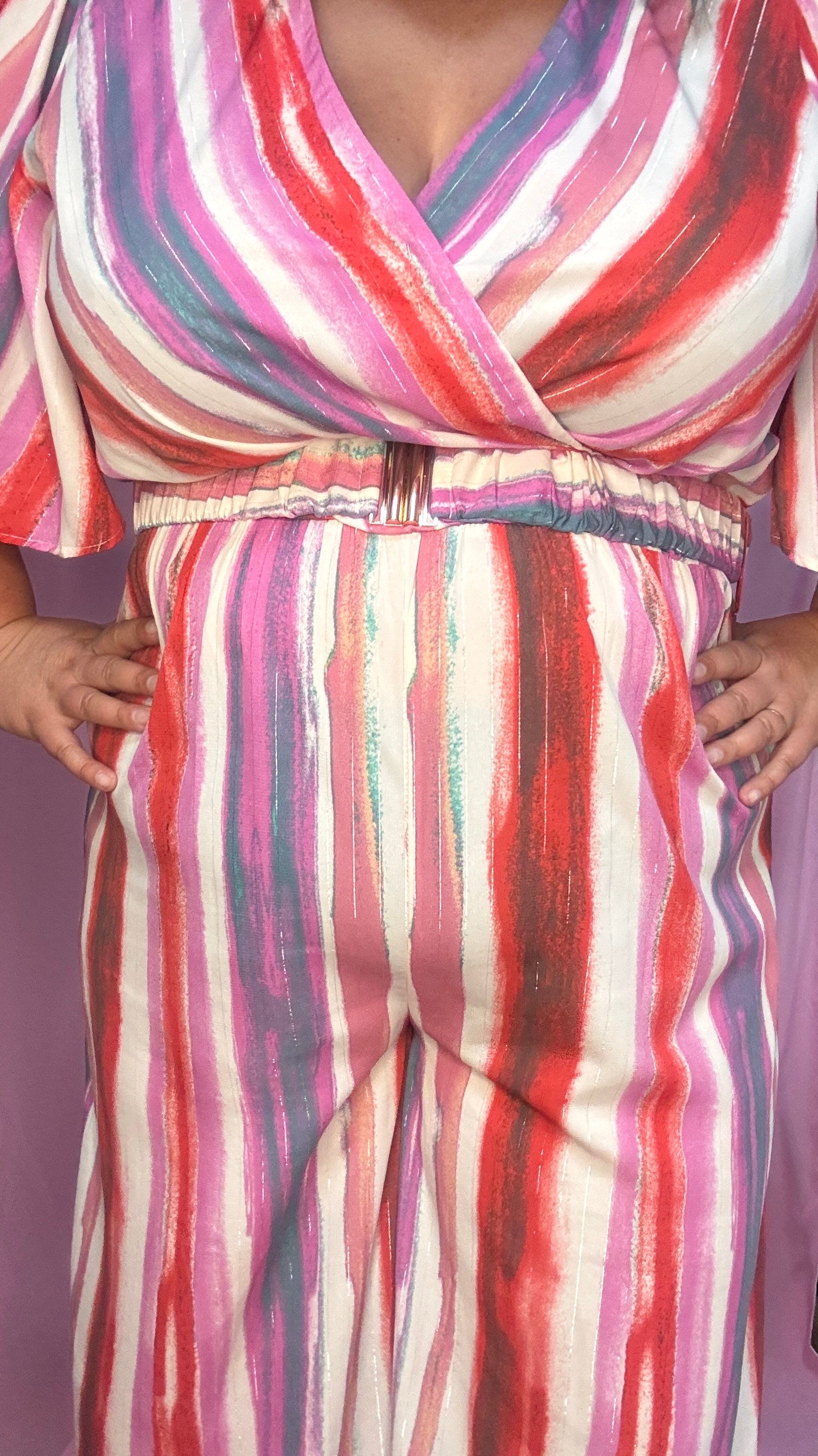 Cette combinaison grande taille aux motifs rayures verticales dans des tons roses, rouge, blanc et violet allonge visuellement la silhouette et attire tous les regards. 