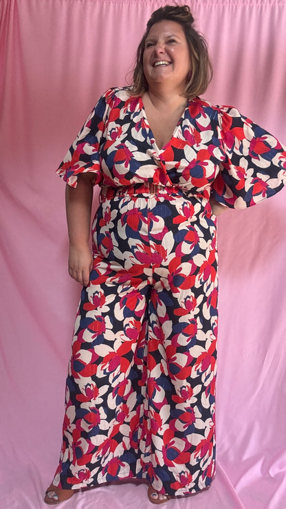 Cette combinaison grande taille au motif fleuri rouge, blanc, bleu roi et rose est un vrai bijou : elle apporte une touche de fraîcheur et d’élégance tout en assurant un confort maximal.