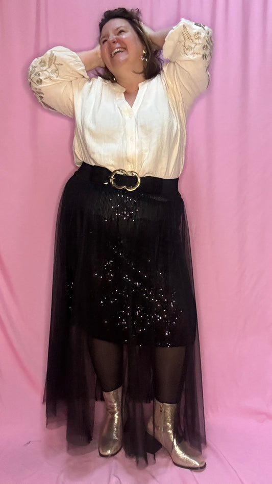 Cette jupe longue grande taille noire avec sequins et tulle est un choix parfait pour celles qui souhaitent se démarquer avec élégance et légèreté . Une pièce chic et unique qui fera sensation lors de vos événements !