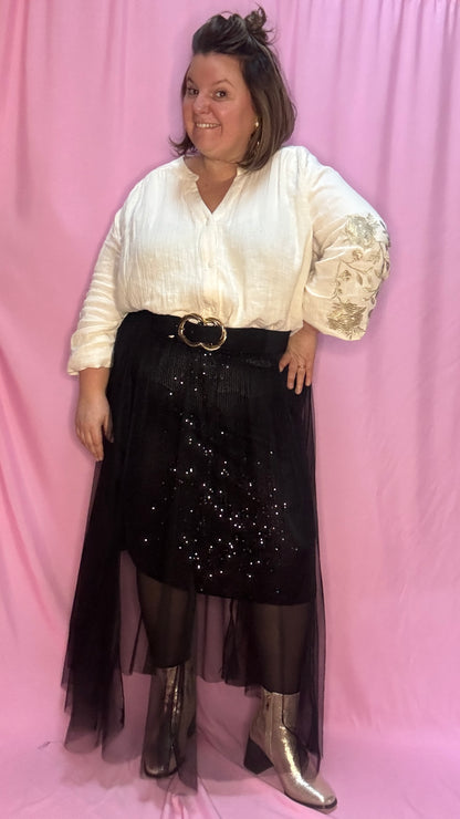 Cette jupe longue grande taille noire avec sequins et tulle est un choix parfait pour celles qui souhaitent se démarquer avec élégance et légèreté . Une pièce chic et unique qui fera sensation lors de vos événements !