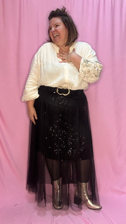 Cette jupe longue grande taille noire avec sequins et tulle est un choix parfait pour celles qui souhaitent se démarquer avec élégance et légèreté . Une pièce chic et unique qui fera sensation lors de vos événements !