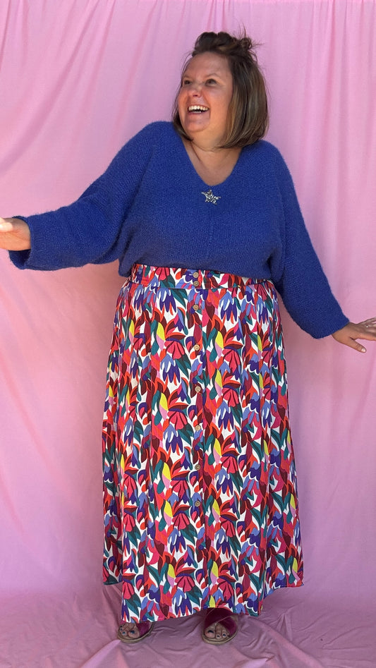 Mettez de la joie dans vos tenues avec cette jupe longue grande taille aux motifs multicolores ! 💛💙💗 Une véritable ode à la vitalité avec ses teintes vibrantes de jaune, bleu, rose, rouge, vert et blanc,