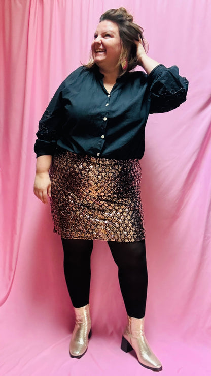 Cette mini jupe grande taille à sequins dorés et bronze est un atout incontournable pour toutes les femmes qui souhaitent briller et se démarquer. Confortable, pratique et éblouissante, elle sera votre meilleure alliée pour rayonner en toutes occasions !