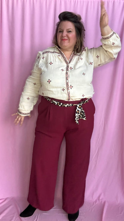 Avec ce pantalon grande taille fluide bordeaux et taille haute, arborez un style coloré et artistique tout en profitant d'un confort incomparable. Original avec sa ceinture léopard