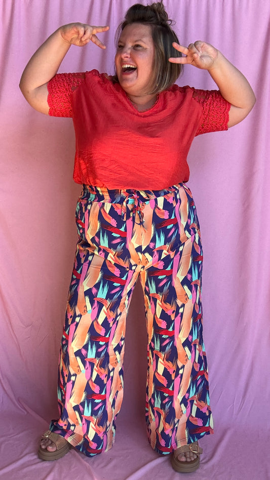 Un pantalon grande taille fluide et coloré pour illuminer toutes tes journées ! Avec ses motifs multicolors pleins de pep’s