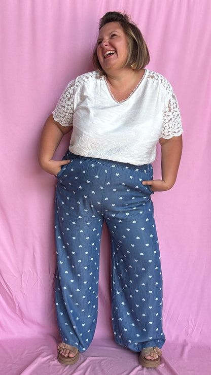 Avec sa coupe droite et jambes larges, ce pantalon fluide bleu jean motifs coeur blanc est parfait pour bouger librement tout en étant stylée.