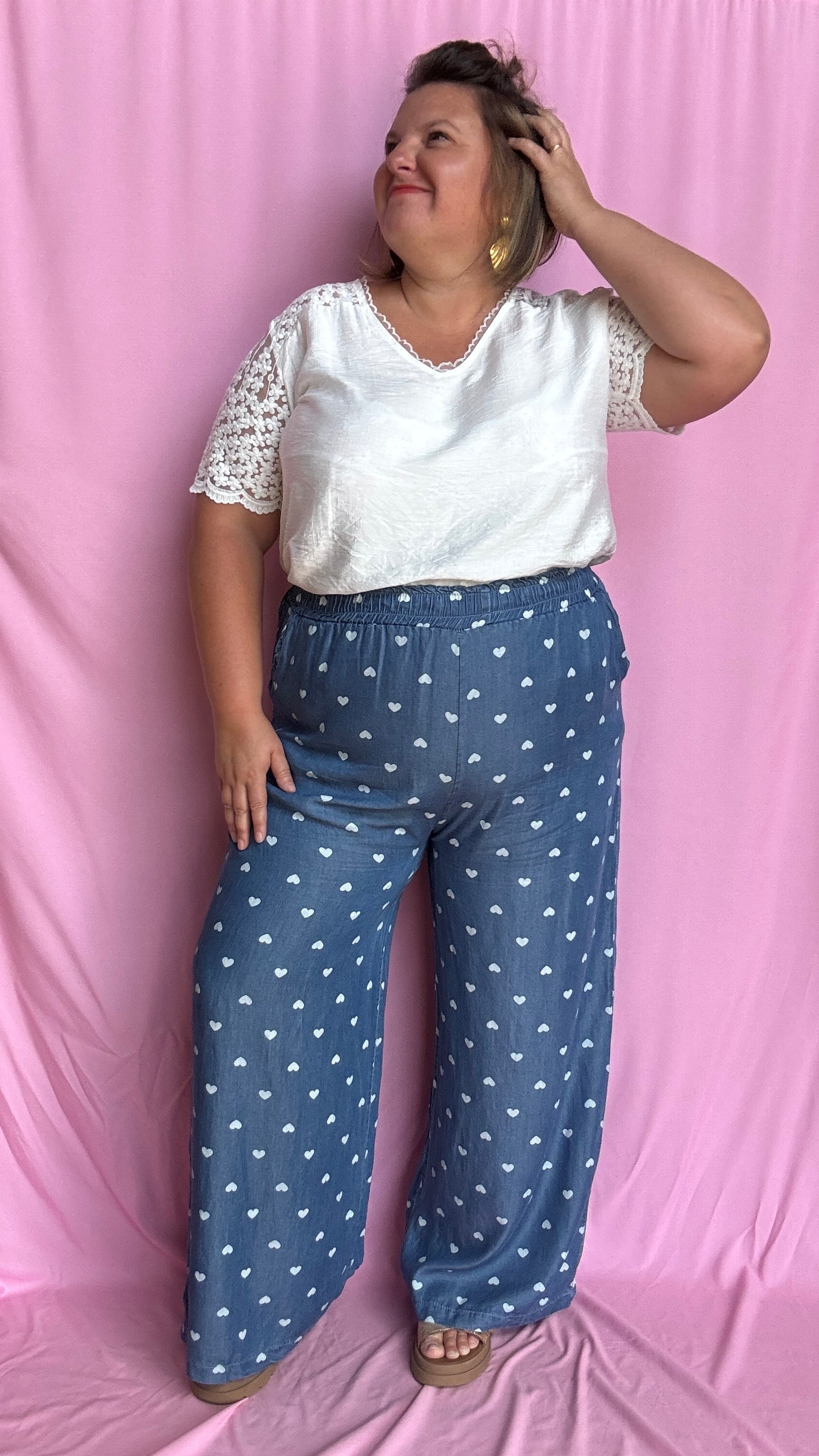 Avec sa coupe droite et jambes larges, ce pantalon fluide bleu jean motifs coeur blanc est parfait pour bouger librement tout en étant stylée.