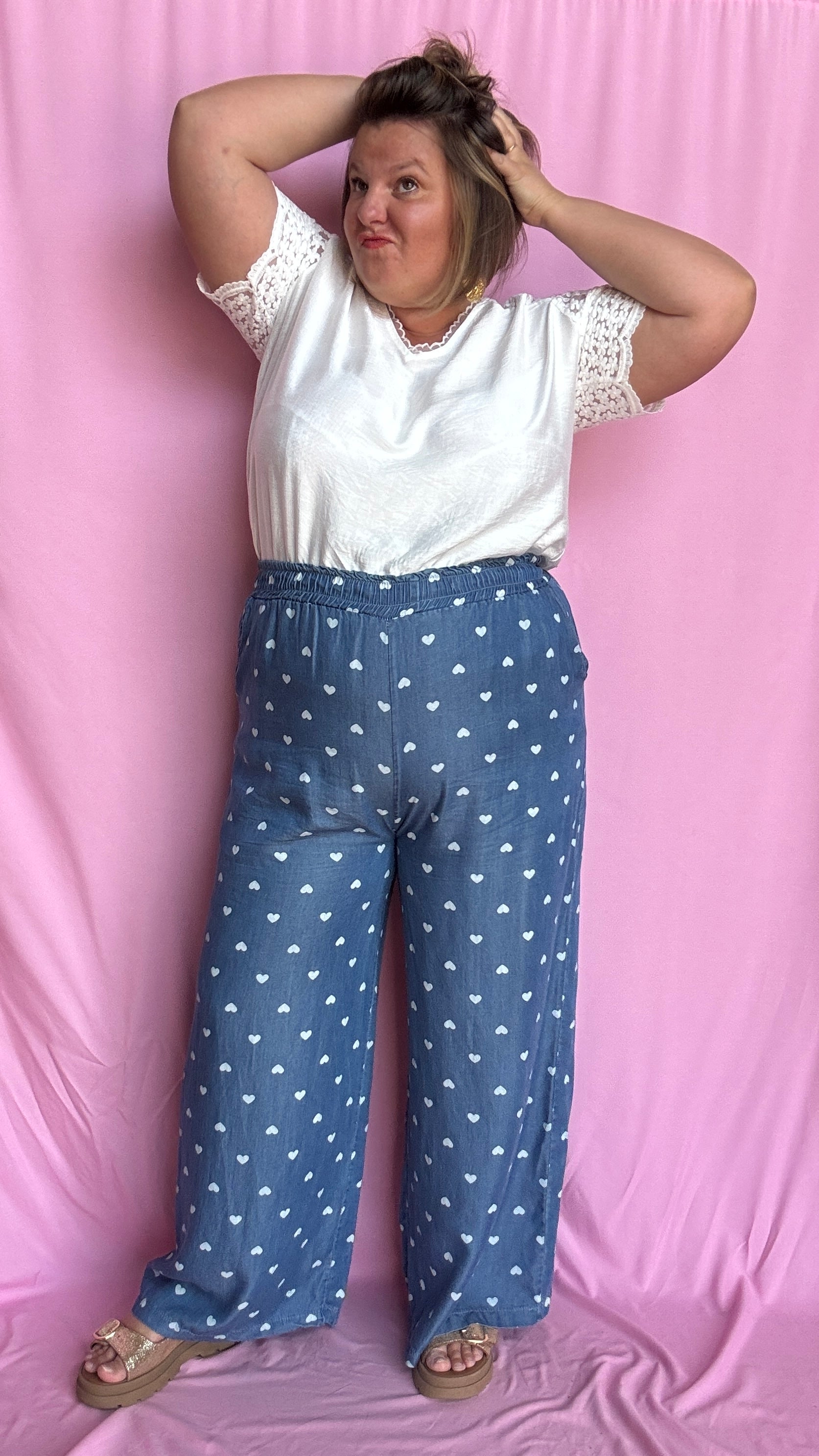 Avec sa coupe droite et jambes larges, ce pantalon fluide bleu jean motifs coeur blanc est parfait pour bouger librement tout en étant stylée.