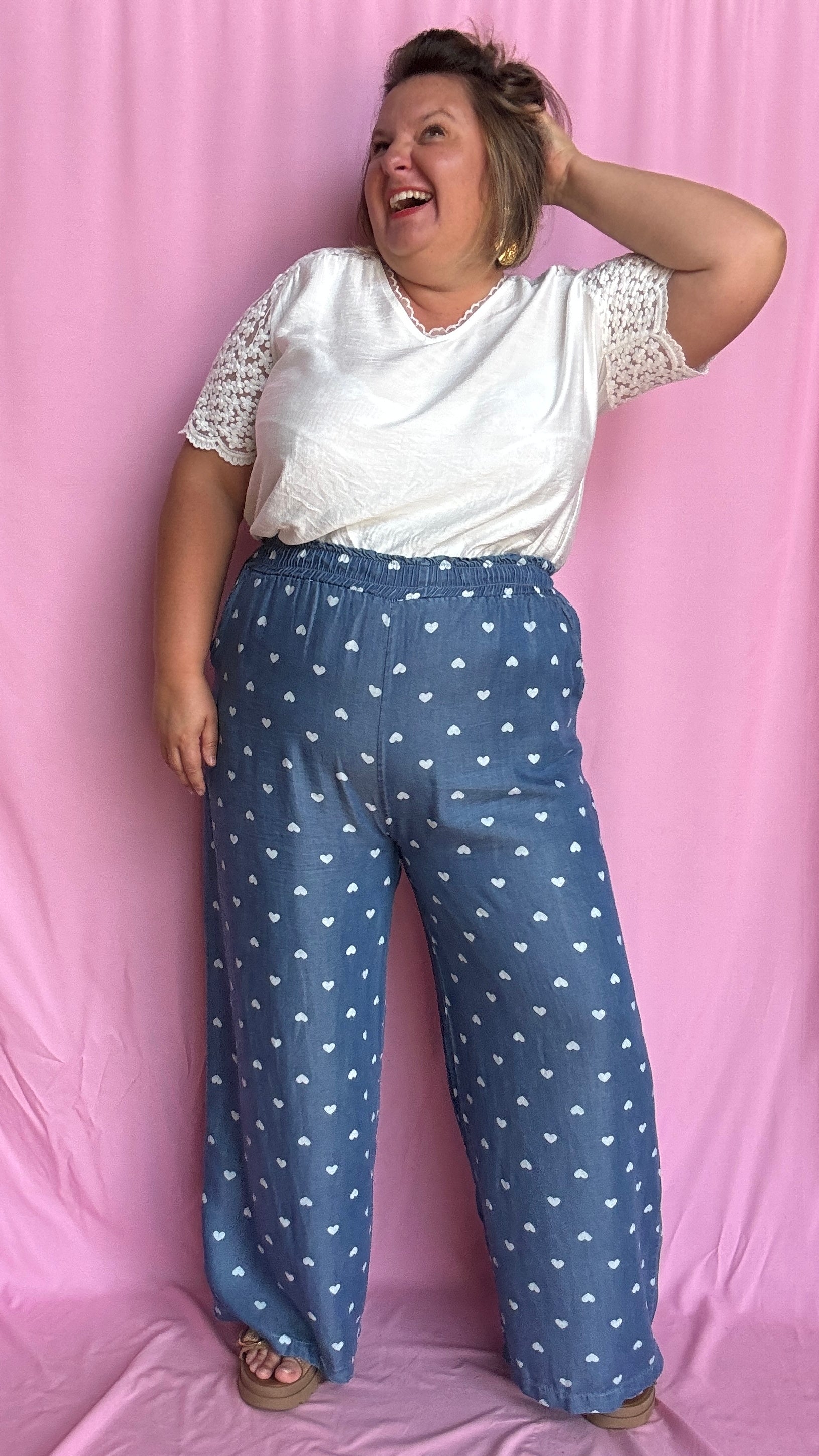 Avec sa coupe droite et jambes larges, ce pantalon fluide bleu jean motifs coeur blanc est parfait pour bouger librement tout en étant stylée.