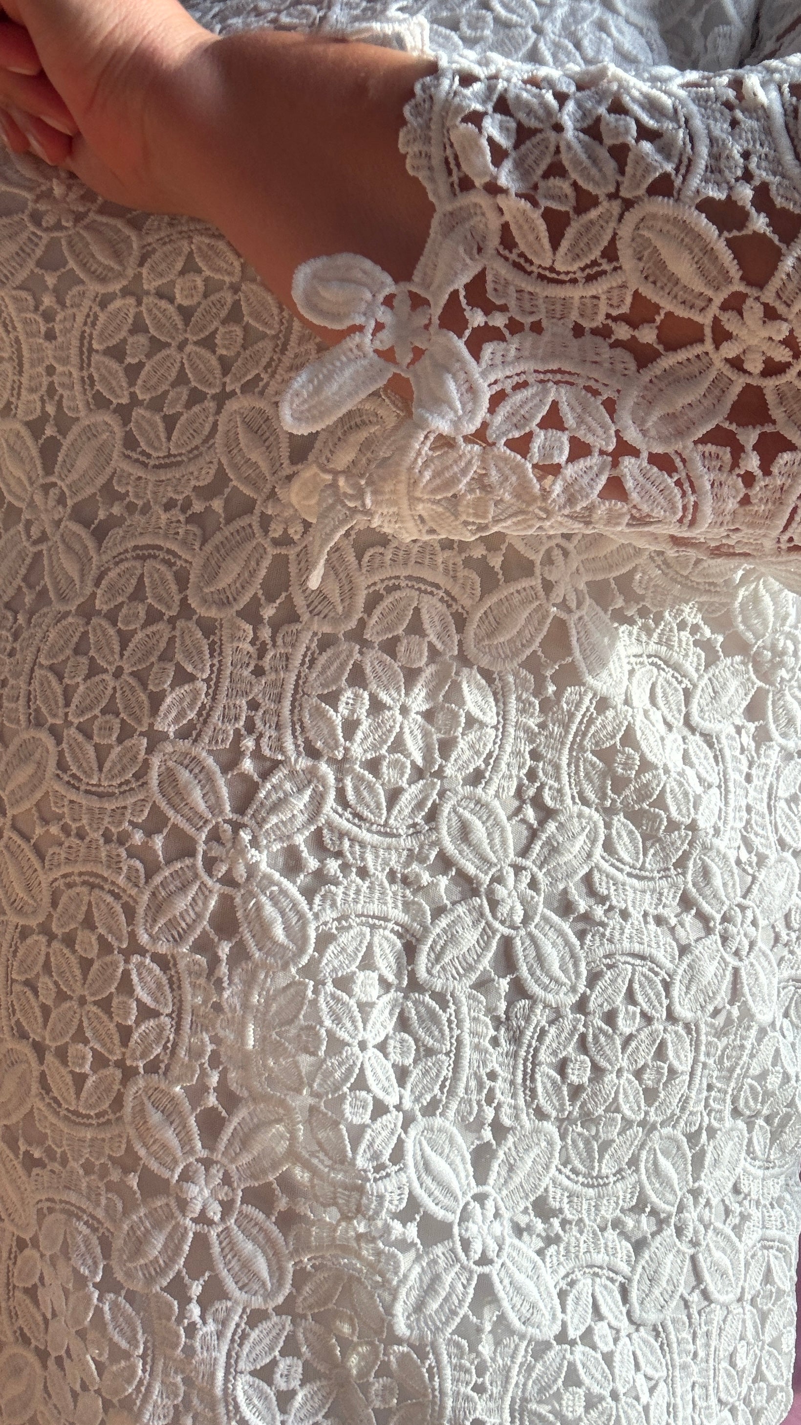Succombez au charme de cette robe blanche grande taille à la coupe droite délicatement ornée de broderies florales ton sur ton.