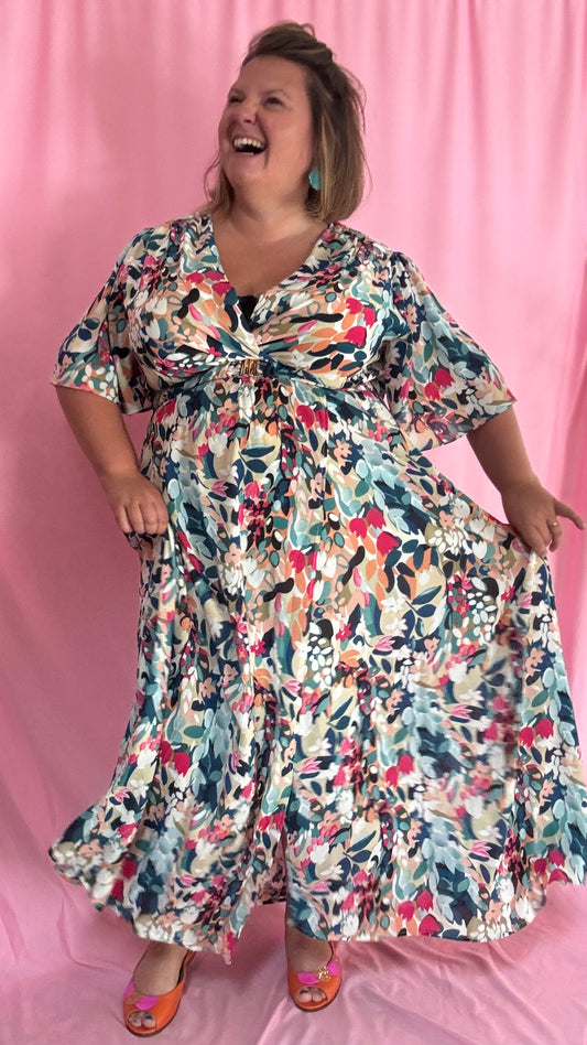 Plonge dans un univers de féminité et de poésie avec cette robe longue grande taille aux motifs délicats vert d’eau, bleu et rose.