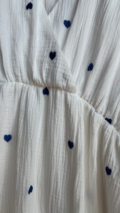 Cette robe longue grande taille en gaze de coton blanche est sublimée par de jolis motifs cœurs bleus qui ajoutent une touche de tendresse et de fantaisie 