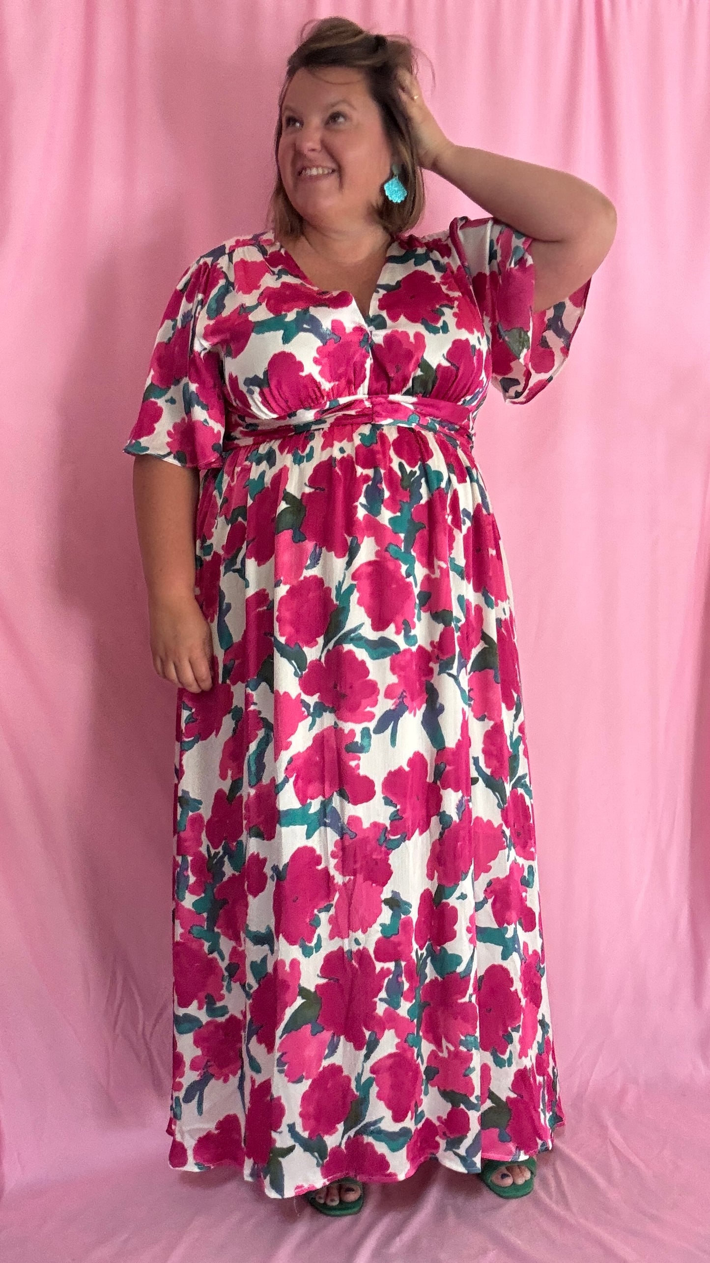 Laisse-toi séduire par cette robe longue grande taille aux motifs fleuris roses, verts et blancs, une pièce aussi délicate qu'élégante.