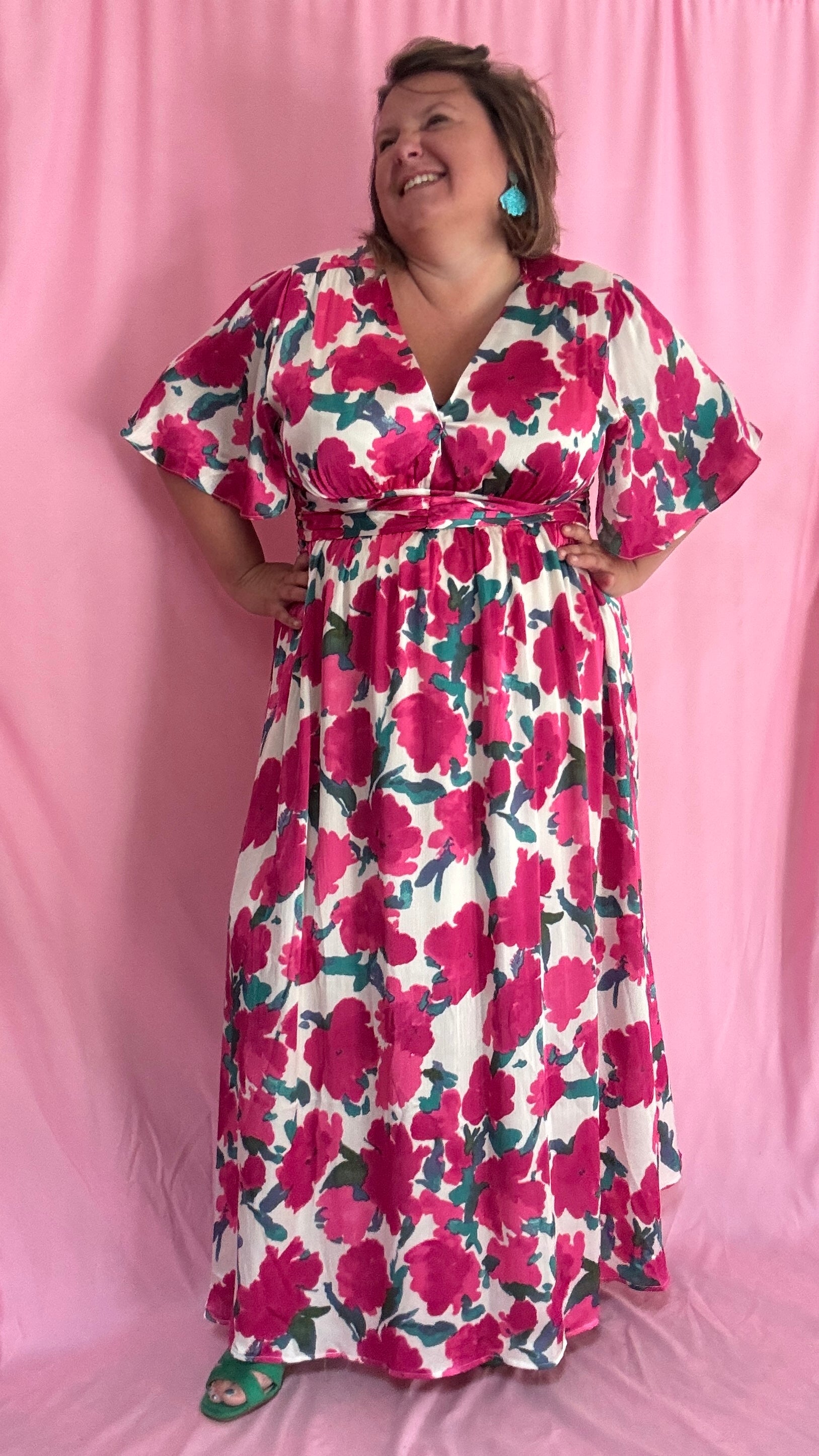 Laisse-toi séduire par cette robe longue grande taille aux motifs fleuris roses, verts et blancs, une pièce aussi délicate qu'élégante.