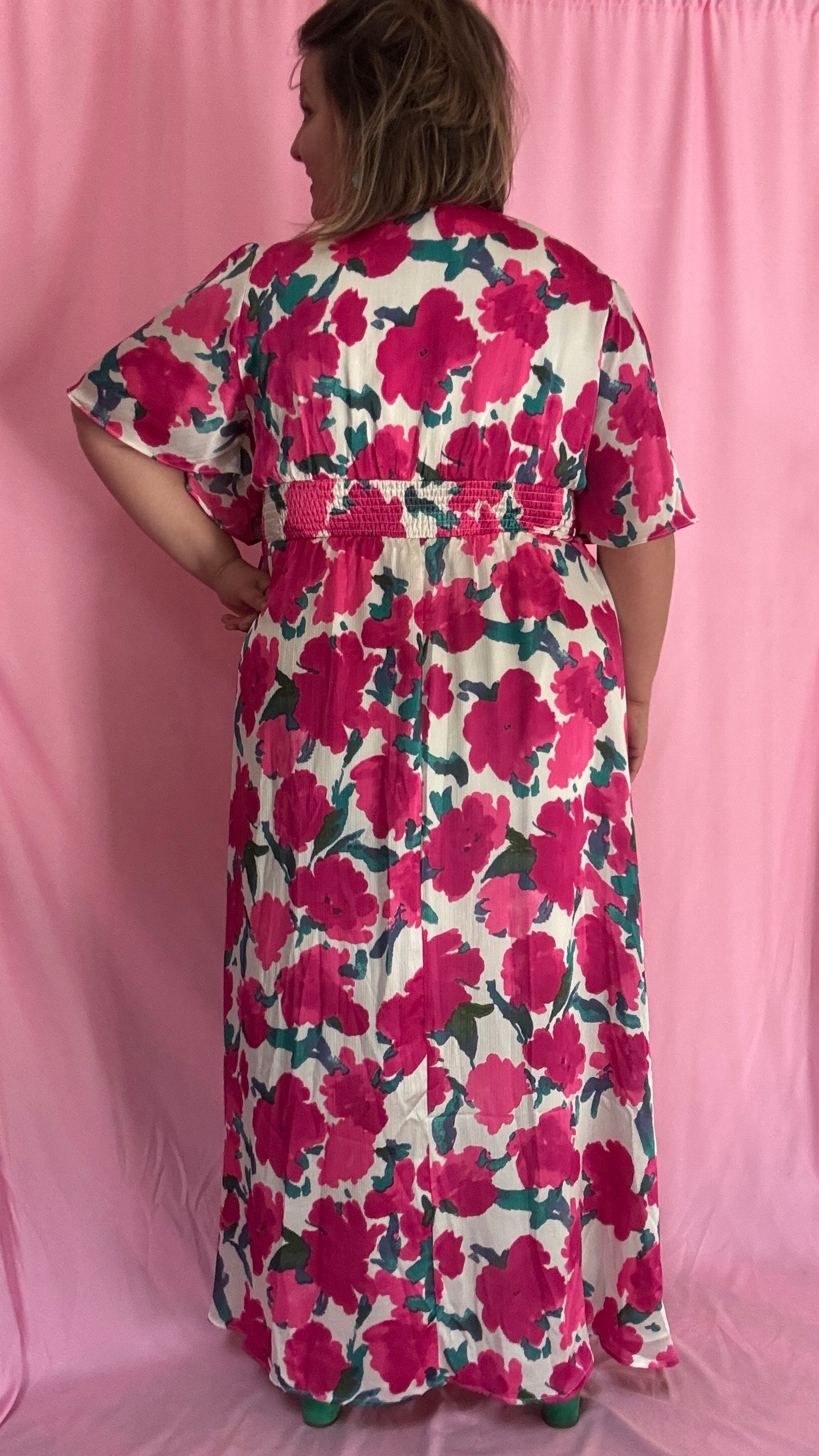 Laisse-toi séduire par cette robe longue grande taille aux motifs fleuris roses, verts et blancs, une pièce aussi délicate qu'élégante.
