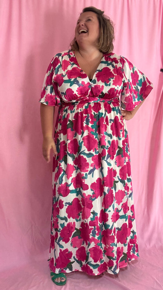 Laisse-toi séduire par cette robe longue grande taille aux motifs fleuris roses, verts et blancs, une pièce aussi délicate qu'élégante.