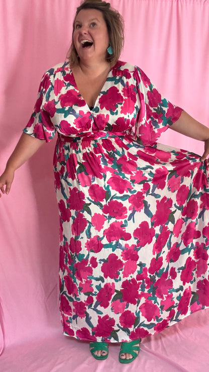 Laisse-toi séduire par cette robe longue grande taille aux motifs fleuris roses, verts et blancs, une pièce aussi délicate qu'élégante.