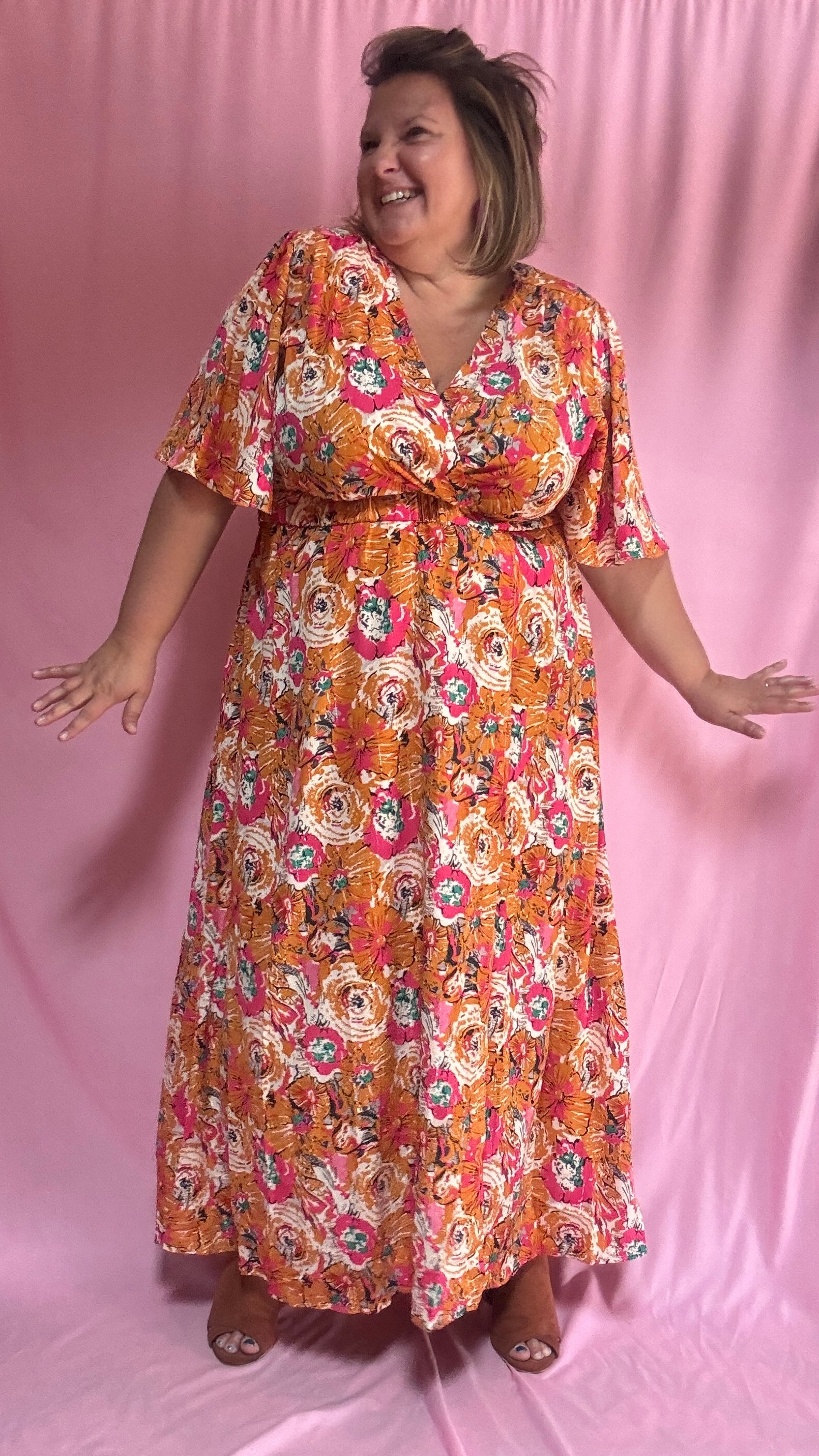 Un vent de fraîcheur et de féminité souffle sur ta garde-robe avec cette magnifique robe longue grande taille aux motifs fleuris dans des tons orange et rose 🌷
