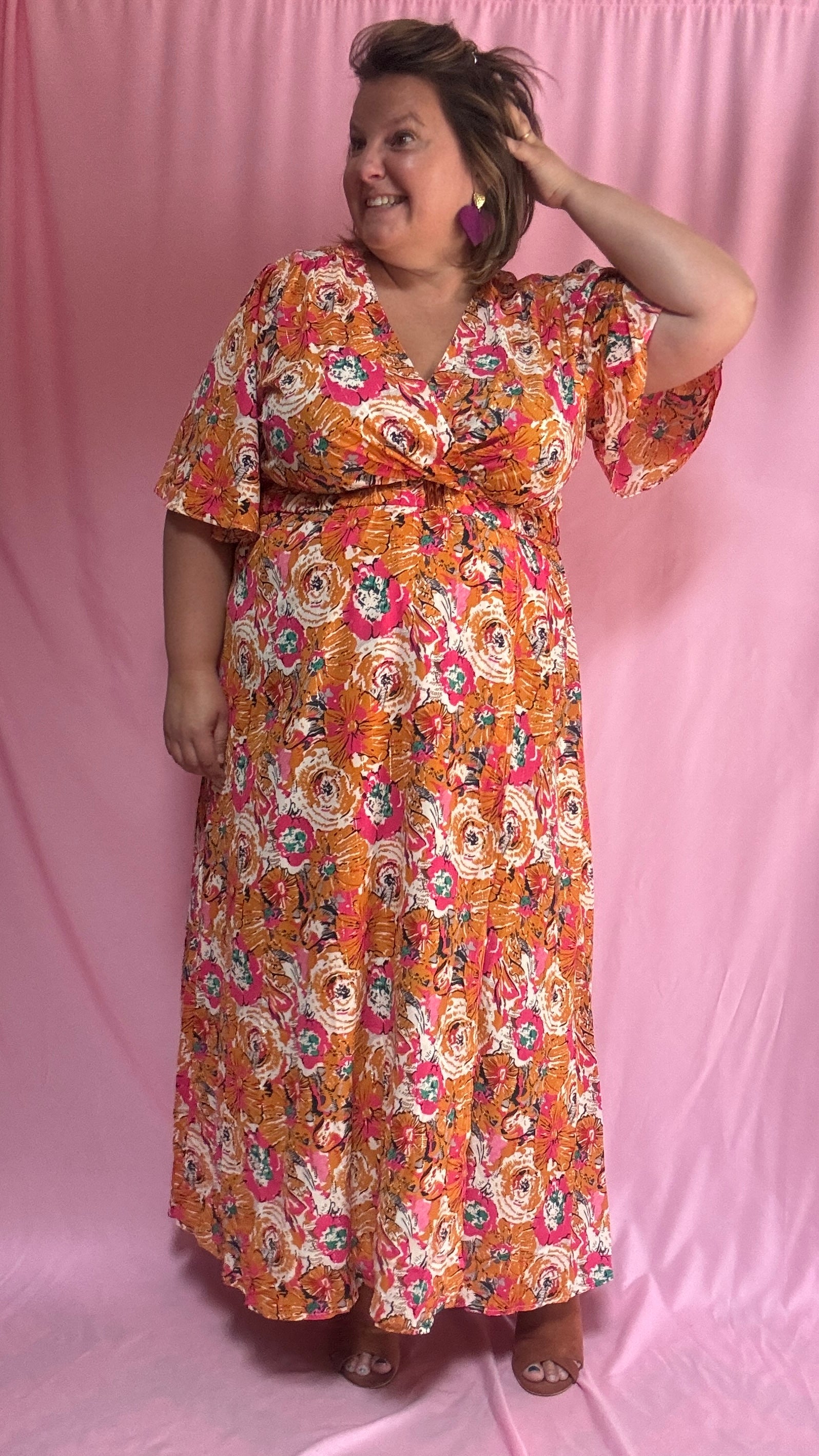 Un vent de fraîcheur et de féminité souffle sur ta garde-robe avec cette magnifique robe longue grande taille aux motifs fleuris dans des tons orange et rose 🌷