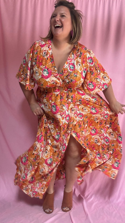 Un vent de fraîcheur et de féminité souffle sur ta garde-robe avec cette magnifique robe longue grande taille aux motifs fleuris dans des tons orange et rose 🌷