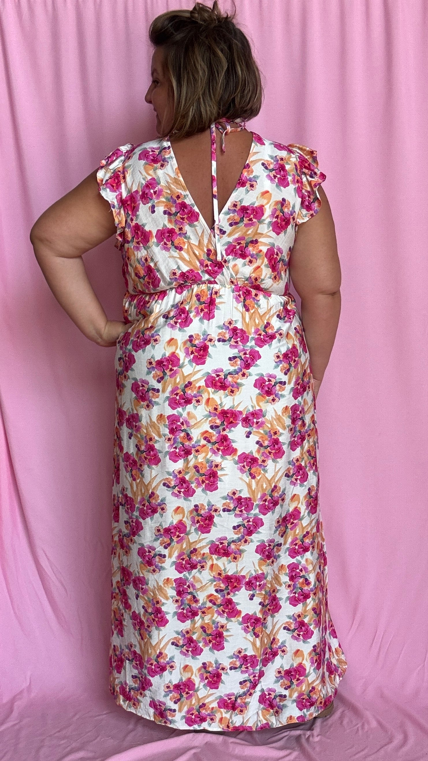 Cette robe grande taille fluide et féminine marie à merveille un fond beige doux avec de jolis motifs fleuris rose orangé,