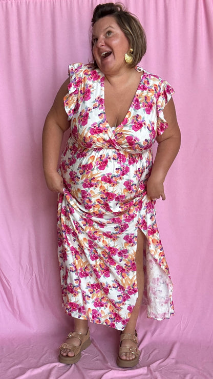 Cette robe grande taille fluide et féminine marie à merveille un fond beige doux avec de jolis motifs fleuris rose orangé,