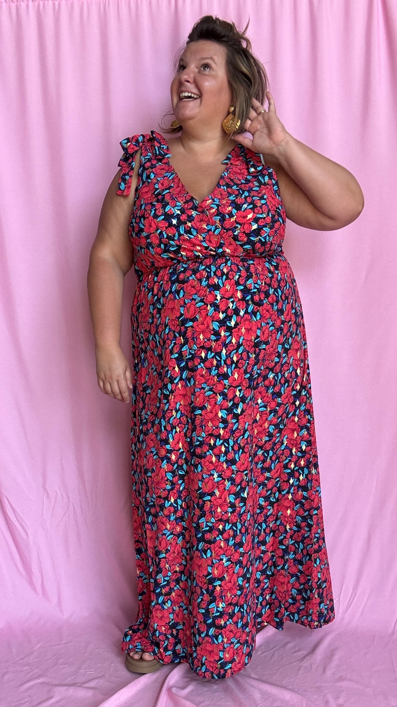 Une robe longue grande taille ultra féminine et pleine d'élégance, avec ses magnifiques motifs fleuris dans les tons rouge, bleu et doré et son dos nu.