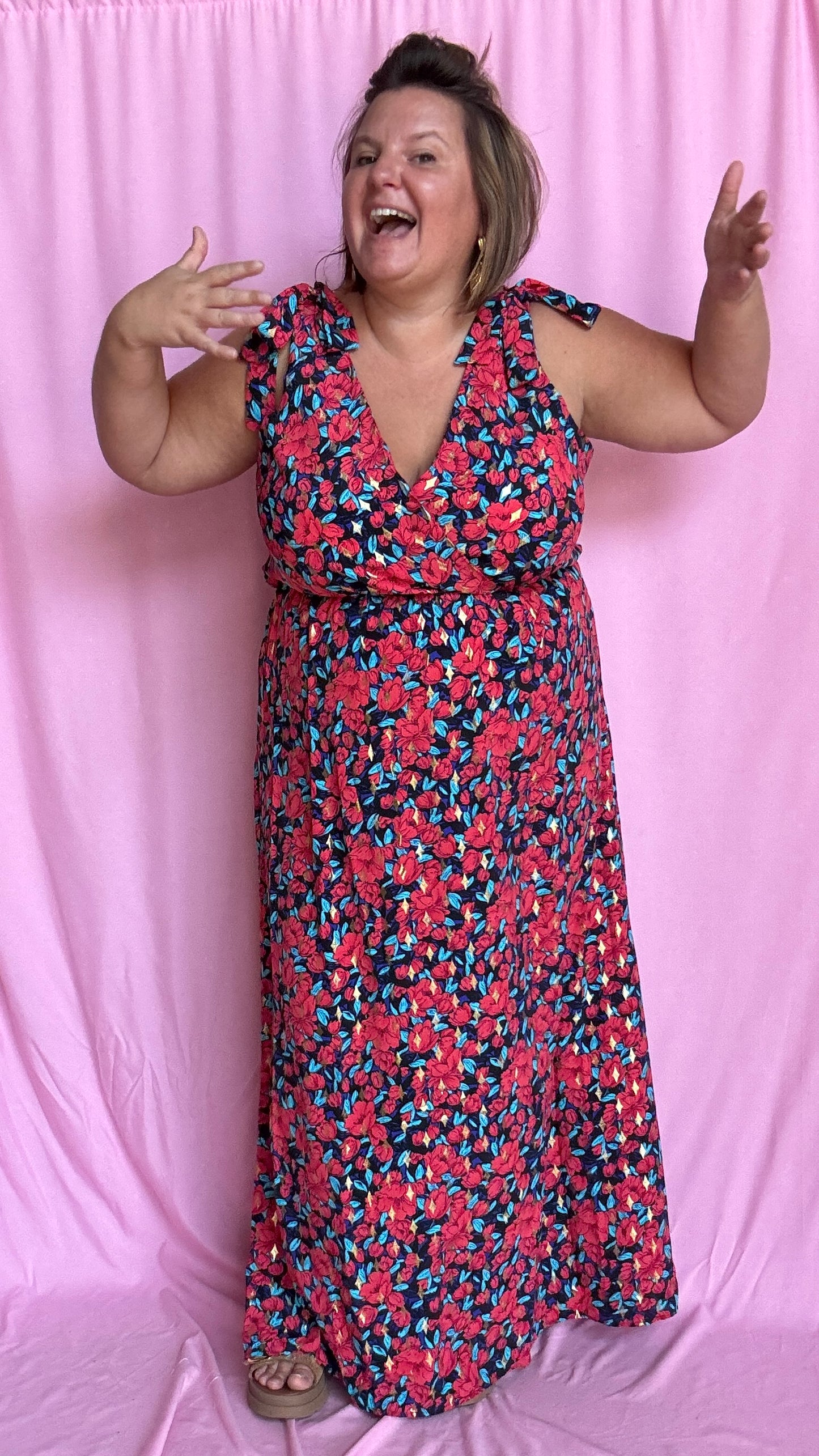 Une robe longue grande taille ultra féminine et pleine d'élégance, avec ses magnifiques motifs fleuris dans les tons rouge, bleu et doré et son dos nu.