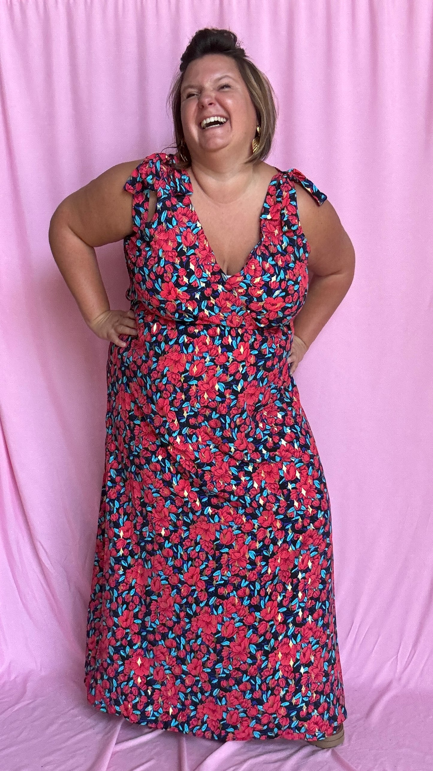 Une robe longue grande taille ultra féminine et pleine d'élégance, avec ses magnifiques motifs fleuris dans les tons rouge, bleu et doré et son dos nu.